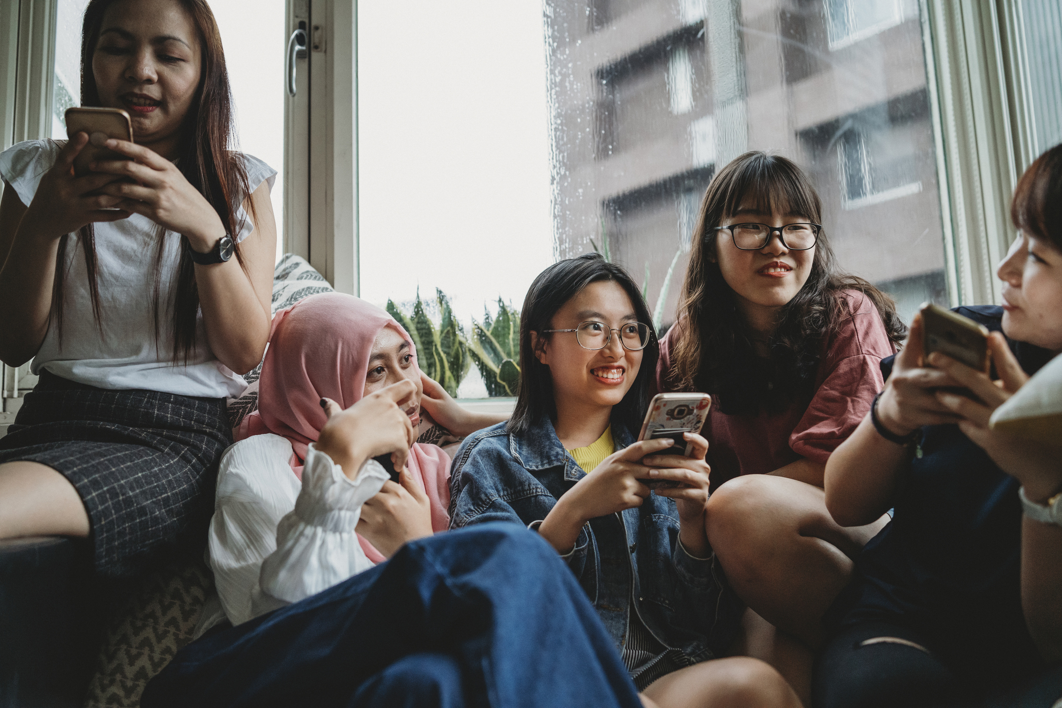 Alt Text: Group of young women using mobile phones together
