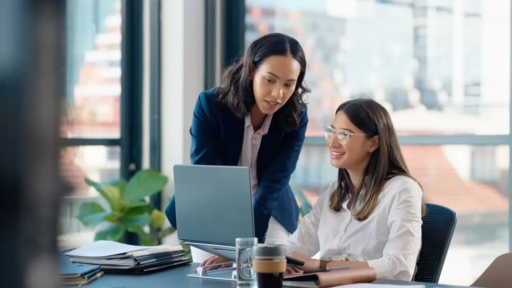 ALT Text: Business people, laptop or learning in training in discussion or conversation for news, education or advice.