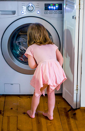 Little girl watching an Energy Star washing machine cycle
